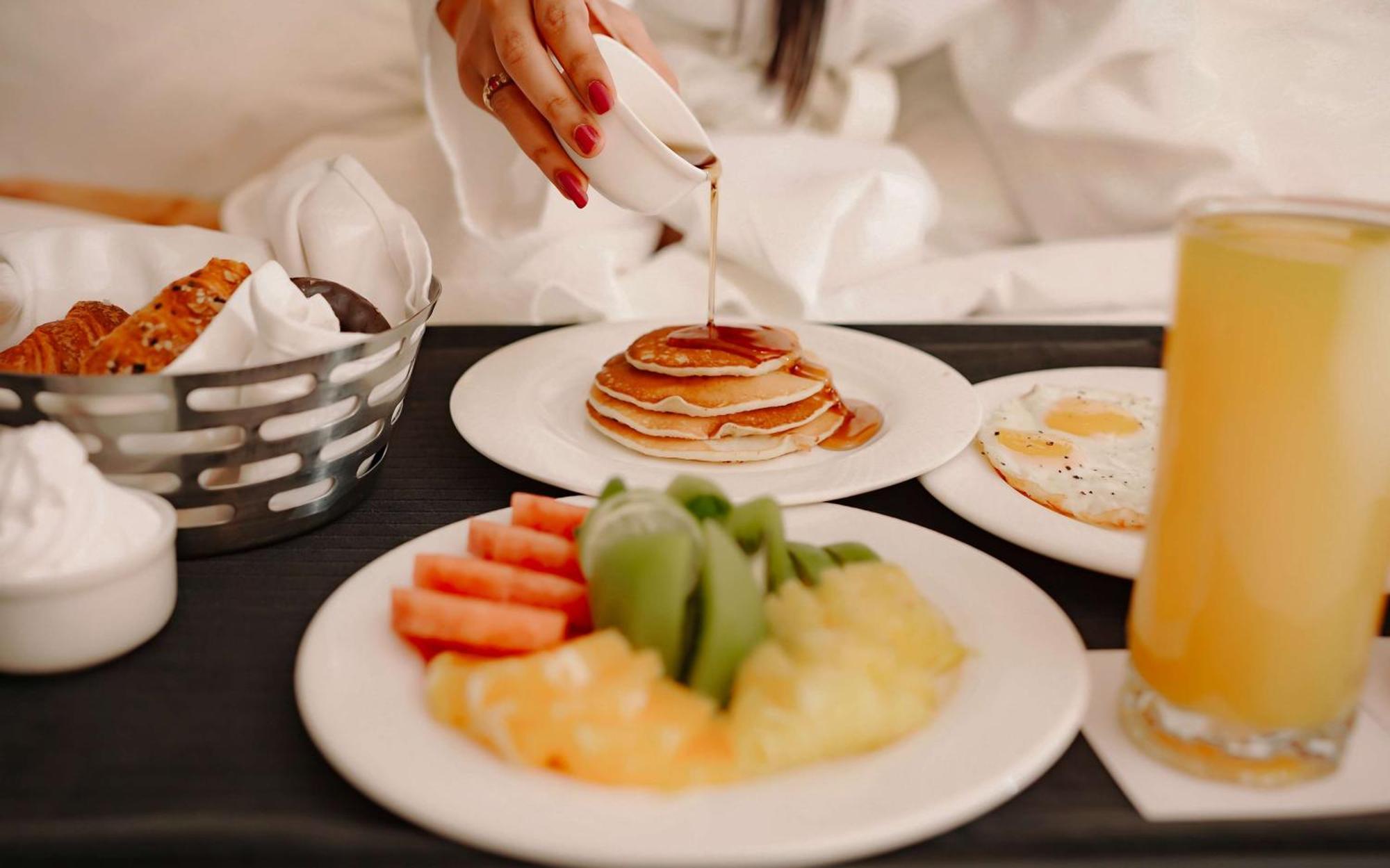 Radisson Blu Hotel אמריצר מראה חיצוני תמונה A woman pouring maple syrup on a stack of pancakes